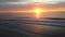 Aerial across Magical sunrise over beach with ocean waves in Maine