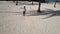 Aerial: African man dancing in a palm grove on the beach