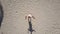 Aerial: African man dancing in a palm grove on the beach