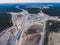 Aerial air view of a massive construction site with a heavy vehicle, bulldozer and excavator, building a new road, working and unl