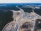 Aerial air view of a massive construction site with a heavy vehicle, bulldozer and excavator, building a new road, working and unl