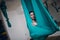 Aerial antigravity yoga concept. Woman practicing fly yoga in anti-gravity yoga studio using green hammock.