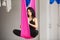 Aerial antigravity yoga girl in lotus pose on silk hammock