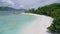 Aerial approaching view of lonely tourist boat moored in tropical exotic blue lagoon with clear blue ocean water and