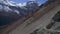 Aerial approaching zoom in view donkey carriage with sherpas on trail to Tilicho base camp in high Himalaya mountain