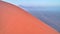 Aerial, artistic photo of dune with climber on its edge. Early morning Namib desert covered in mist. Orange dunes of Namib from