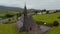 Aerial ascending footage of historic structure of stone church of St John the Baptist. Old religious landmark with tower