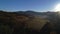 Aerial autumn sunrise scenery with yellow larches, small village and Odle - Geisler mountain group on background. Alps