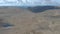 An aerial backward reveal footage of a Scottish summit plateau with huge cliff in the background