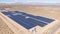 AERIAL: Barren landscape surrounds a large farm of solar panels in California.