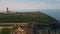 Aerial beautiful coastal panorama with lighthouse rising at ocean shore cliff