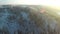 AERIAL: Beautiful flight down above frozen forest. Winter sunset