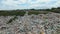 AERIAL: Big piles of empty bottles, bags and other plastic in the garbage dump