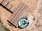 Aerial bird`s eye drone view of a wood fired stainless steel outdoor jacuzzi and a wooden deck with stairs