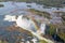 Aerial bird`s-eye view of beautiful rainbow above Iguazu Falls Devil`s Throat chasm from a helicopter flight. Brazil and Argentina