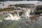 Aerial bird`s-eye view of beautiful rainbow above Iguazu Falls Devil`s Throat chasm from a helicopter flight. Brazil and Argentina