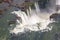 Aerial bird`s-eye view of beautiful rainbow above Iguazu Falls Devil`s Throat chasm from a helicopter flight. South America.