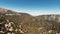 Aerial bird`s eye view of mountains densely covered with brown trees in California, USA