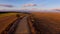 Aerial bird view footage flight over rural road in beautiful countryside landscape at sunset.