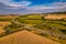 Aerial bird view of typical Ardennes green field meadows and hill landscape also showing highway and buildings in te far