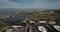 Aerial birds eye view of shoreline lake Google campus amphitheater park mountain background pan left