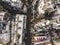 Aerial black and white winter top view of modern city with tall buildings, parked and moving cars along streets with road marking