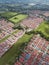 Aerial of blocks of red roofed townhouses and fields of farmland in Malagasang, Imus, Cavite