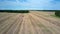 Aerial boundless harvested field under blue sky