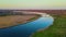 Aerial of bridge over blue river with lot of driving heavy cargo trucks at sunset at evening