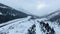 Aerial camera films winter road at the foot of the snowy mountain slopes in Kananaskis, Alberta, Canada