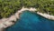 Aerial of cape Kamenjak in Croatia surrounded by turquoise water and people vacationing on the beach