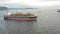 Aerial: Cargo ship in motion with construction equipment on deck