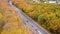 Aerial cars driving road in yellow autumn forest