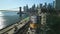 Aerial cinematic shot of cityscape with Brooklyn Bridge, Manhattan skyscrapers and busy expressway on riverbank. New