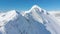 AERIAL: Cinematic shot of a majestic snowy mountain ridge in the sunny Alps.