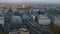 Aerial cinematic shot of modern high speed train stopping at platform at Berlin Hauptbahnhof. Cityscape at twilight in