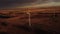 Aerial cinematic sunset wind farm under a colourful sky producing sustainable energy