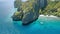 Aerial circle fly above coral reef and banca boats at the beach of limestone rocky Entalula Island, Bacuit Bay, El-Nido