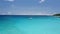 Aerial circle footage of luxury catamaran yacht boat moored in transparent turquoise blue lagoon with white clouds on