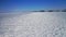 Aerial circle panning view, alone tourist come over wide snow hummock field