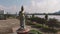 Aerial circle round a large Angkorian style statue standing on a pedestal in Cambodia,