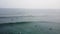 Aerial circling view over the surfers in the sea paddling and resting in water waiting for waves.