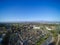 Aerial city view with roads, buildings, parks and parking lots.