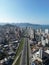 Aerial cityscape with cars, urban buildings by Meia Praia beach in Itapema City in Brazil