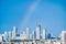 Aerial cityscape shot of buildings in gurgaon delhi noida with a rainbow behind them on a monsoon day