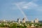 Aerial cityscape shot of buildings in gurgaon delhi noida with a rainbow behind them on a monsoon day