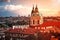 Aerial cityscape view on the lesser town with saint Nicholas church in Prague city. Warm sunset light with birds