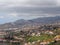 Aerial cityscape view of the outskirts of funchal in Madeira with farms and houses with mountains and cloudy sky in the distance