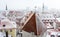 Aerial cityscape view of Tallinn Old Town on winter day. Red rooftops from tiles, Golden Cockerel weathervane, Town Hall spire,