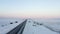 AERIAL: Close Up of Jeep brake lights driving on Iceland Road with Snow white Mountains and Sunset Snow, Arctic